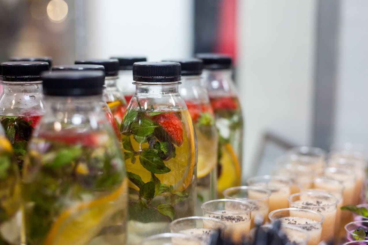 services-01 Close-up of plastic bottles with fruit-infused water and herbs, perfect for a refreshing drink.